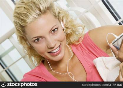 Portrait of a young woman listening to an MP3 player