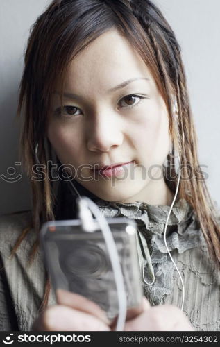 Portrait of a young woman listening to an MP3 player