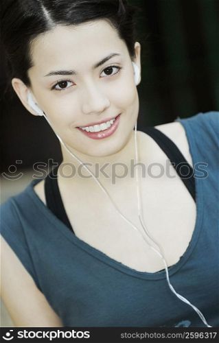 Portrait of a young woman listening to music and smiling