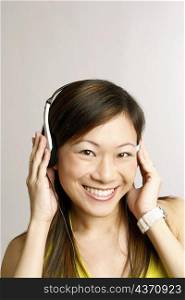 Portrait of a young woman listening to music and smiling