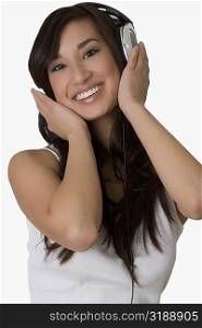 Portrait of a young woman listening to music with headphones and smiling