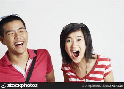 Portrait of a young woman looking surprised with a young man smiling