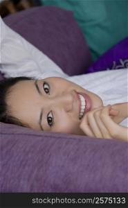 Portrait of a young woman lying down and smiling