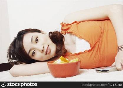 Portrait of a young woman lying down holding a mobile phone