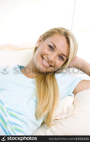Portrait of a young woman lying down on a bed