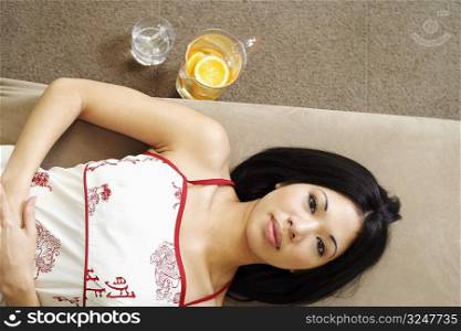 Portrait of a young woman lying on a couch