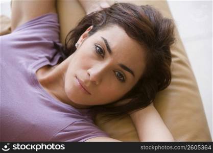 Portrait of a young woman lying on a couch and looking serious