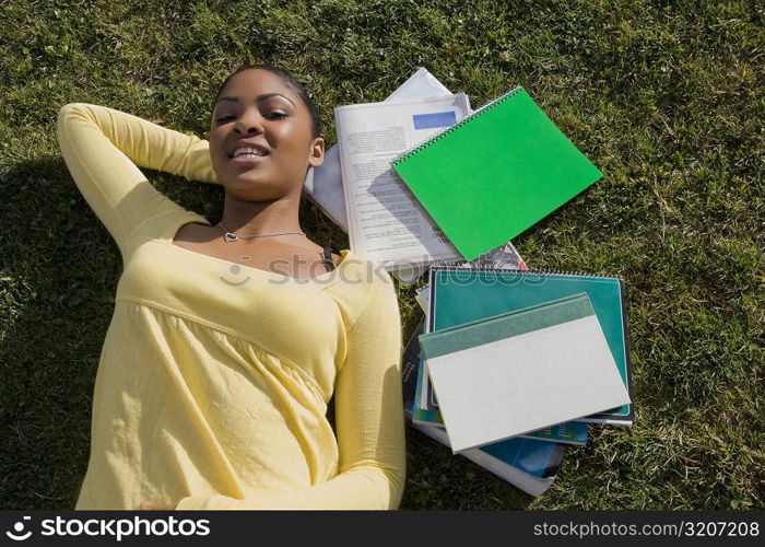 Portrait of a young woman lying on grass and smiling