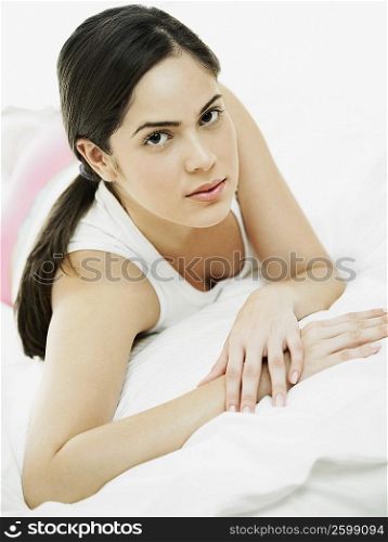 Portrait of a young woman lying on the bed