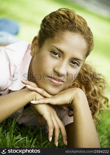 Portrait of a young woman lying on the grass