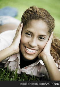 Portrait of a young woman lying on the grass