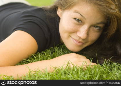 Portrait of a young woman lying on the grass