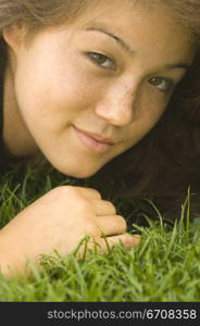 Portrait of a young woman lying on the grass