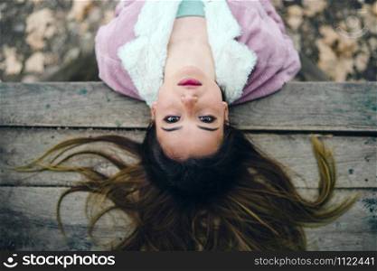 Portrait of a Young Woman Lying on the wood table in park M