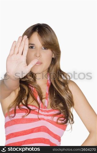 Portrait of a young woman making a stop gesture
