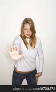 Portrait of a young woman making a stop gesture