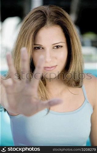 Portrait of a young woman making a stop sign