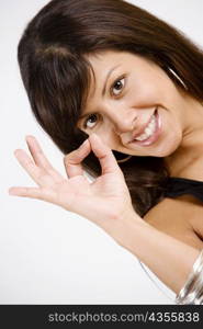 Portrait of a young woman making an OK sign and smiling
