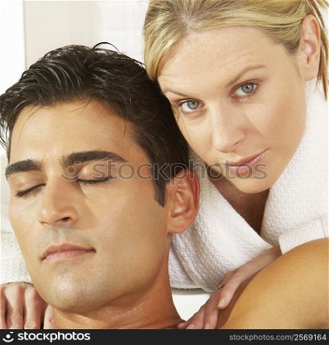 Portrait of a young woman massaging a young man