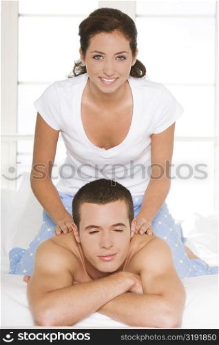 Portrait of a young woman massaging a young man&acute;s shoulders