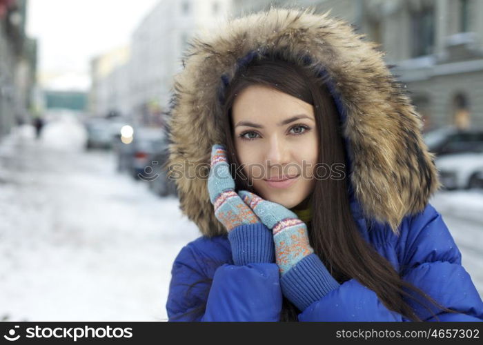 Portrait of a young woman on the background of a winter city