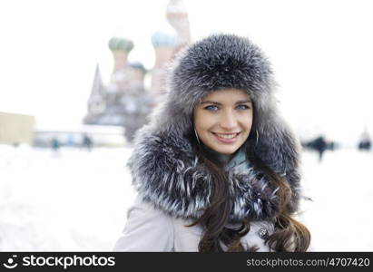 Portrait of a young woman on the background of a winter city