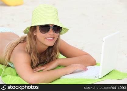 portrait of a young woman on the beach with laptop