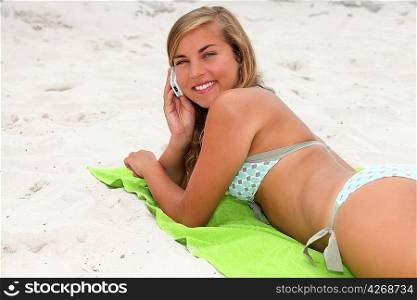portrait of a young woman on the beach with phone