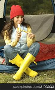 Portrait of a young woman peeling a banana