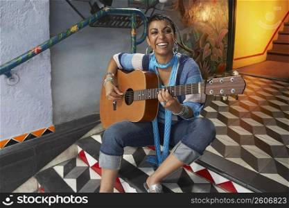 Portrait of a young woman playing a guitar