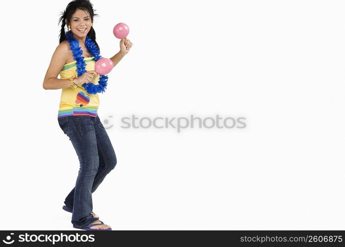 Portrait of a young woman playing maracas and smiling