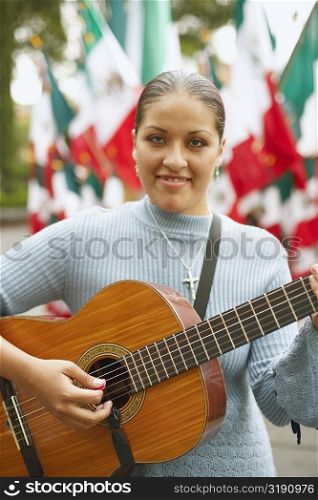 Portrait of a young woman playing the guitar