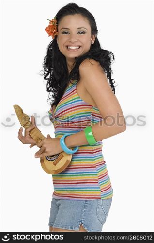 Portrait of a young woman playing ukulele and smiling