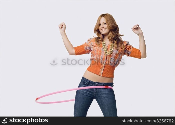 Portrait of a young woman playing with a hula hoop