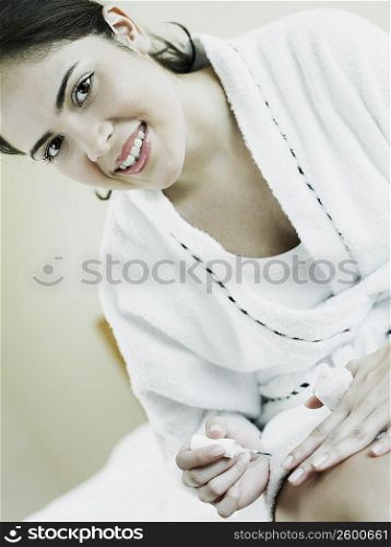 Portrait of a young woman polishing her nails