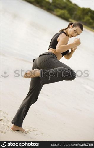 Portrait of a young woman practicing martial arts on the beach