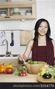 Portrait of a young woman preparing food in the kitchen smiling