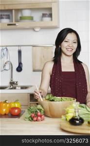 Portrait of a young woman preparing food in the kitchen smiling