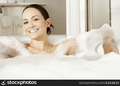 Portrait of a young woman reclining in a bubble bath