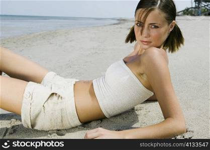 Portrait of a young woman reclining on the beach
