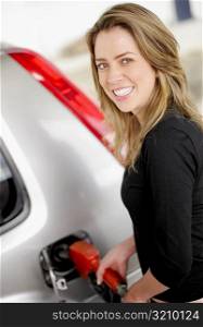 Portrait of a young woman refueling a car