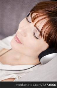 Portrait of a young woman relaxing and listening music with headphones