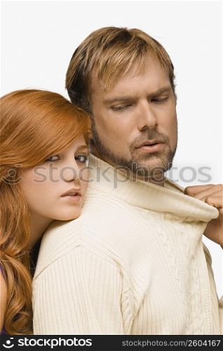 Portrait of a young woman resting her face on the shoulder of a mid adult man