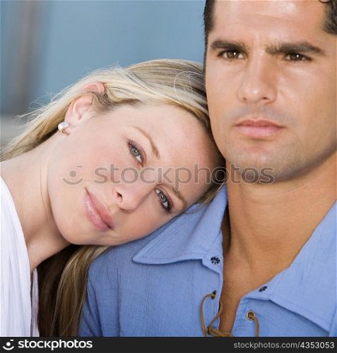 Portrait of a young woman resting her head on a mid adult man&acute;s shoulder