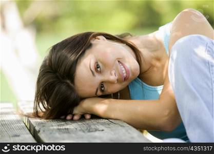 Portrait of a young woman resting on a bench