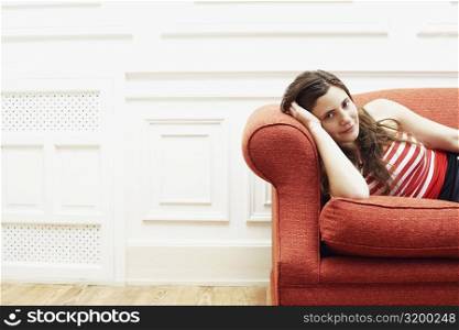 Portrait of a young woman resting on a couch