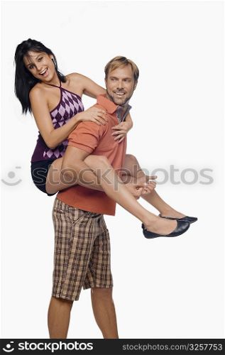 Portrait of a young woman riding piggyback on a mid adult man