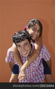 Portrait of a young woman riding piggyback on a young man
