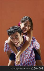 Portrait of a young woman riding piggyback on a young man