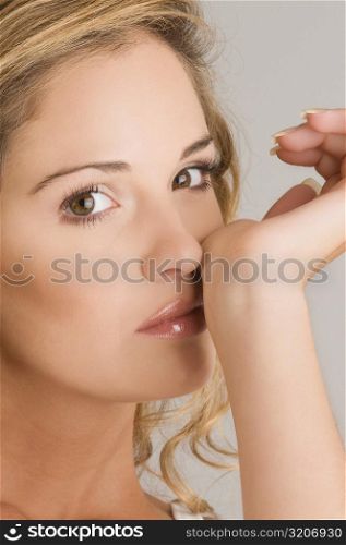 Portrait of a young woman rubbing her nose